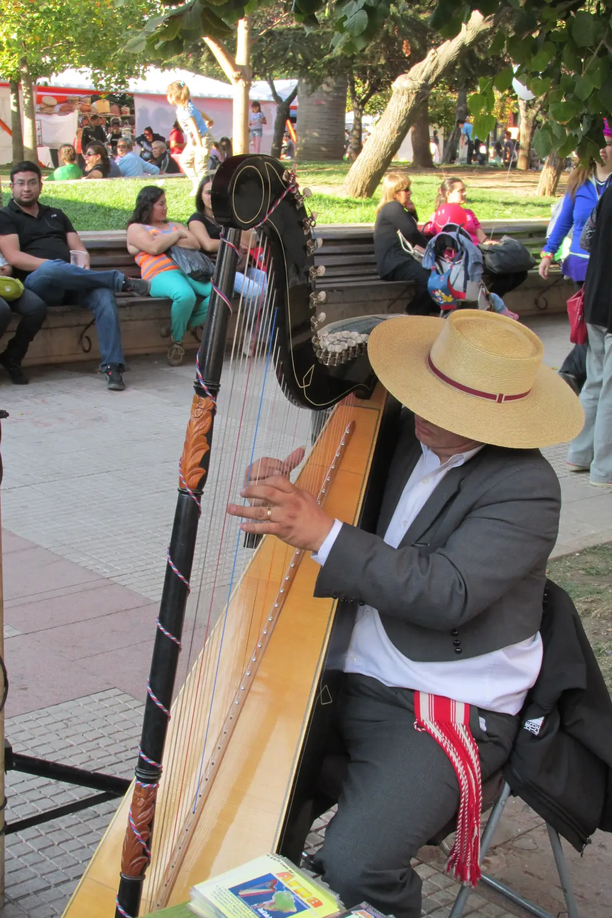 Músico con chupalla tocando el arpa en una fiesta huasa en la plaza de Rancagua.