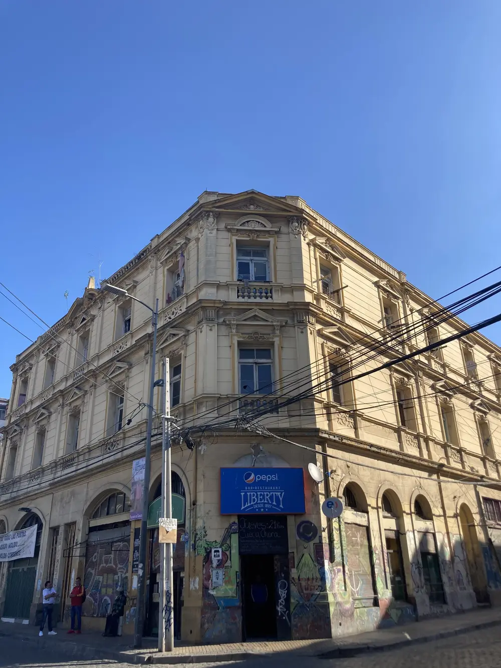 Fachada de esquina del Bar Liberty, edificio antiguo de dos pisos en la plaza Echaurren de Valparaíso.