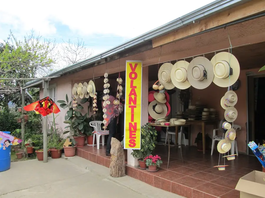Puesto de artesanía con chupallas y sombreros de paja colgados en la cuesta La Lajuela, Santa Cruz.