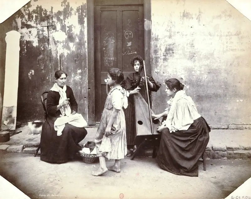 Fotografía antigua de mujeres sentadas en un patio con guitarra y arpa, una de ellas con un niño.
