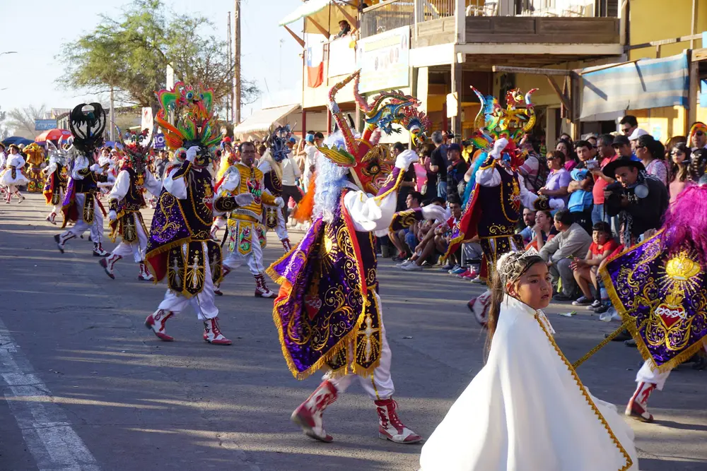 Multitud y bailarines con trajes de colores en la Fiesta de La Tirana, Tarapacá.